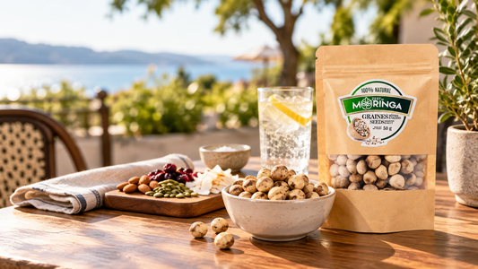 Zest of Moringa Roasted & Salted Moringa Seeds 50g pouch with a bowl of roasted seeds and trail mix on a sunlit outdoor café table.